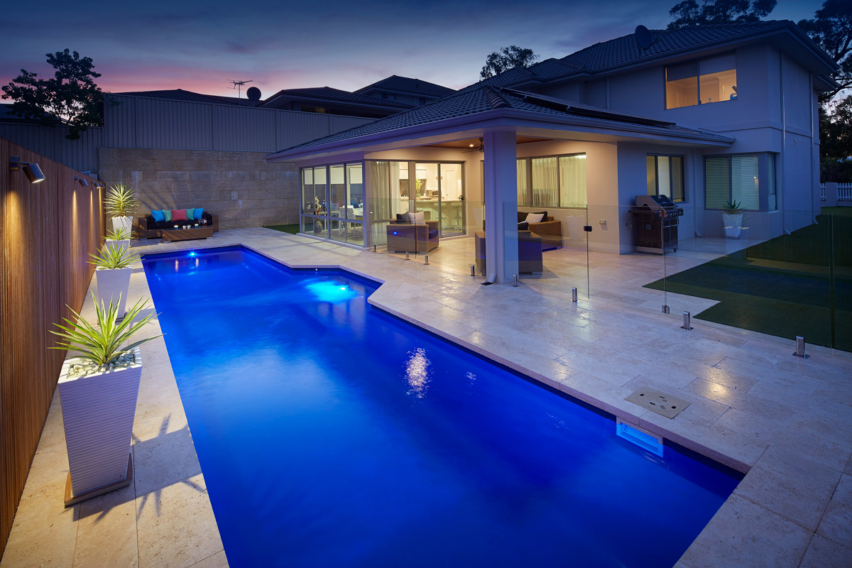 view from fibreglass pool of house with entertainer lighting and landscaping